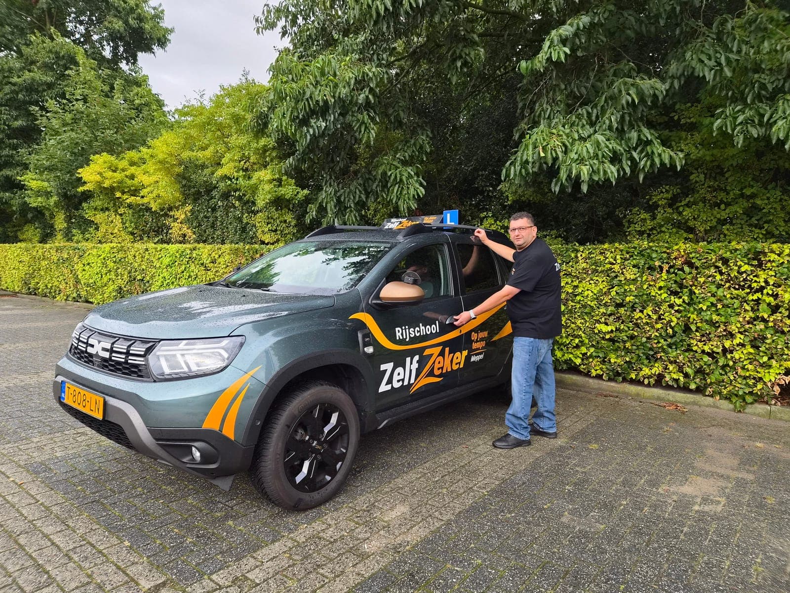 Rani bij de deur van de lesauto