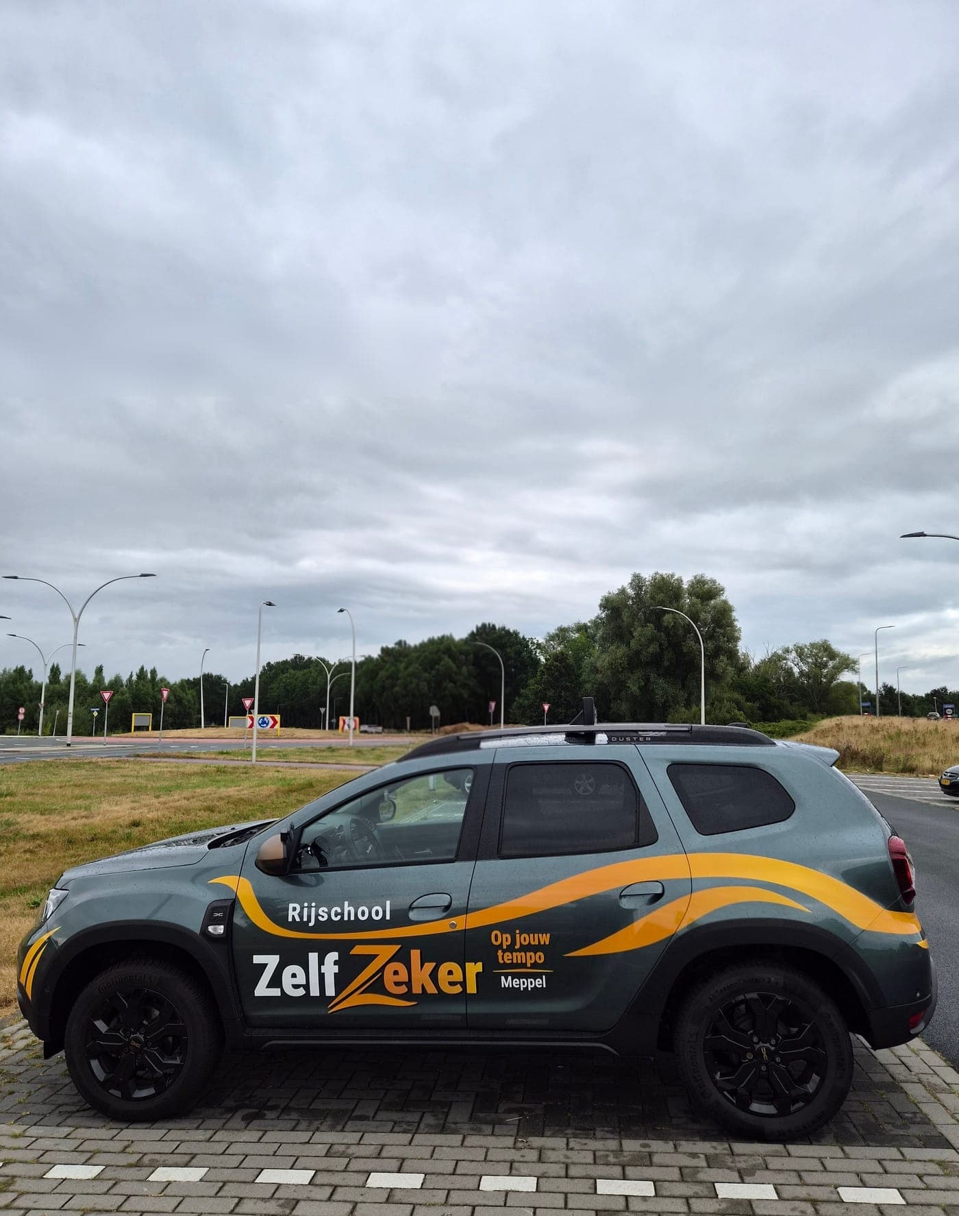 De ZelfZeker-lesauto (Dacia Duster) van opzij