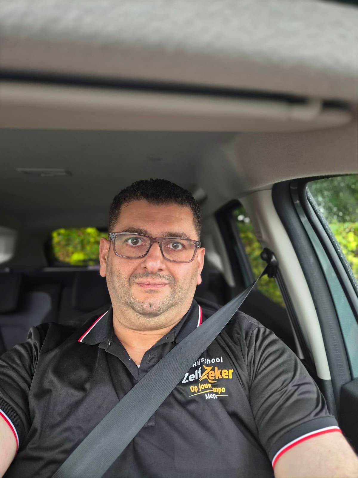 Rani achter het stuur van de lesauto